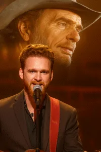 “He Still Talks To His Father Through Every Guitar String.” When Ben Haggard steps on stage, the crowd doesn’t just hear a song — they hear a conversation between generations. Every note of “Mama Tried” sounds like Ben whispering, “I’m still carrying your truth, Dad.” The spotlight may shine on him, but it’s Merle’s shadow that completes the stage. Featured image