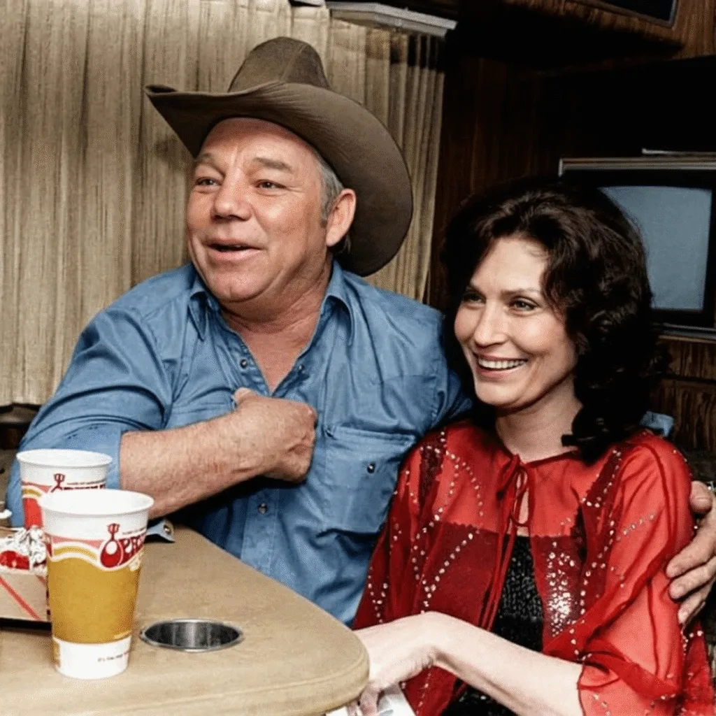 “PLAY HER SONG ONCE — AND YOU’LL NEVER FORGET HER.” They said the road from Washington to Tennessee was too long, too lonely — but Loretta Lynn and her husband, Doo, didn’t listen. They had a record, a beat-up car, and a dream that refused to stay quiet. Every time they stopped at a radio station, Doo would walk in first, dust on his boots and fire in his eyes. “Play her song once,” he’d say, “and you’ll see.” Sometimes they were laughed at. Sometimes ignored. But once in a while — a DJ would drop the needle, and silence would turn into magic. Loretta’s voice floated out into the static, across highways and diners and truck stops. She didn’t know it then, but those long nights, those cracked highways, and those tiny radio booths were building something bigger than fame — they were building her story. The story of a coal miner’s daughter who refused to fade quietly into the mountains. And somewhere, through the hum of that first broadcast, her voice trembled with truth — “So turn that jukebox way up high, and fill my glass up while I cry…” No one knew her name yet, but from that moment on — they would never forget her sound.