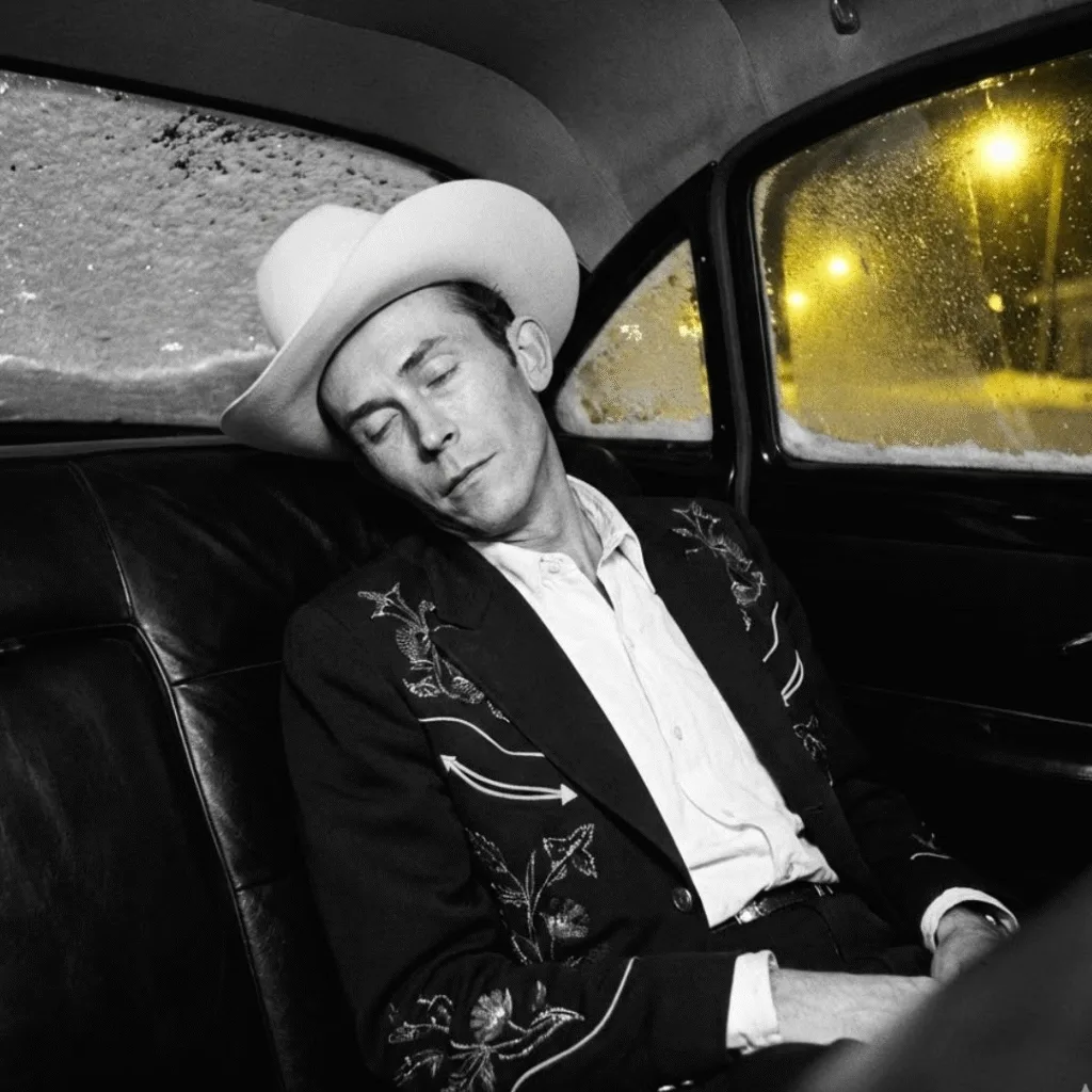 The Day the Music Died: A New Year’s Tragedy. On New Year’s Day, 1953, the world lost a legend in the back seat of a Cadillac. Hank Williams, only 29 years old, left behind a legacy that changed country music forever. With 35 Top 10 Billboard hits—including timeless classics like “Cold, Cold Heart” and “Hey, Good Lookin'”—his success was undeniable. Yet, a haunting shadow hangs over his untimely passing. In a twist of dark irony, his last single released during his lifetime was titled “I’ll Never Get Out of This World Alive.” Was it a premonition? The events leading up to that lonely highway drive are as heartbreaking as “Your Cheatin’ Heart.”