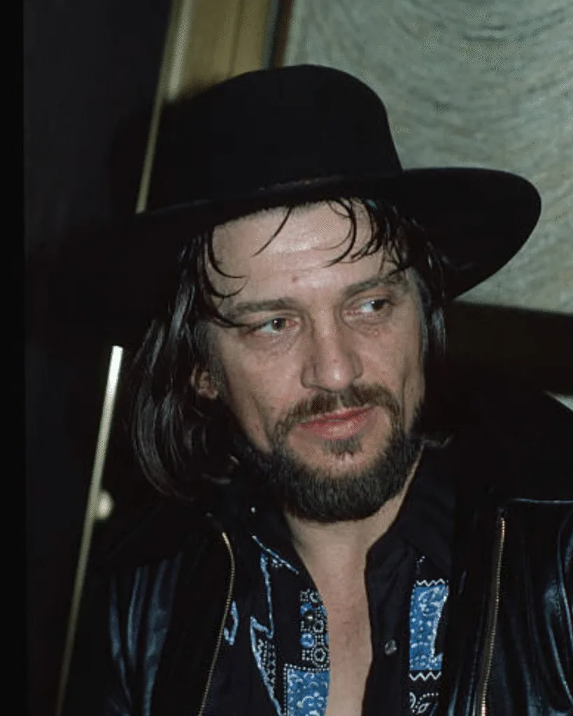 IN 1972, ONE MAN WALKED OUT OF A RECORD DEAL TO SAVE HIS SOUL. He didn’t want the rhinestones. He didn’t want the producer telling him when to breathe. Waylon Jennings wanted something Nashville was afraid to give him: Control. The suits told him he was making a mistake, that the “Nashville Sound” was the only way to sell records. He packed his bags and let his hair grow long. The beat he created wasn’t polished; it was a heartbeat skipping a rhythm. It sounded like a Telecaster growling at the establishment. He replaced the orchestra with a heavy bassline that hit you right in the chest. It wasn’t just music anymore; it was a line drawn in the sand. But what happened the night he finally played his own sound for the first time left the executives speechless…