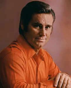 THE 1970s — WHAT REALLY HAPPENED TO GEORGE JONES? Shows were missed. Promises were broken. And somehow, the songs got heavier. George Jones wasn’t just performing country music — he was fighting himself in public. Long nights, missed shows, broken trust, and exhaustion followed him straight onto the stage. People asked the same question again and again: was he battling the devil inside his own chest? His voice changed because he changed. It no longer floated with ease. It cracked, strained, and trembled like a man pushing through wounds he could no longer hide. Some nights, the voice sounded fragile, barely holding together. Other nights, it sounded terrifyingly honest — like truth spoken without protection. Whispers spread that he was finished. That the damage had finally won. But the 1970s were never about decline or redemption. They were about exposure. A great singer stripped of illusion, standing in the open. And once George Jones was exposed, the music carried more weight than ever.